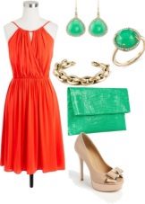 Robe de couleur corail associée à des accessoires verts
