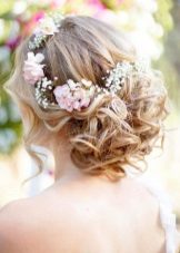 Coiffure avec des fleurs fraîches à la robe de mariée