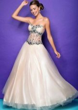 La robe est blanche et verte avec un corset transparent et des strass.