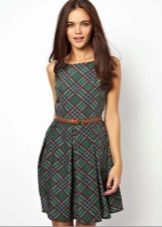 Robe courte en plaid vert avec une fine lanière de cuir rouge
