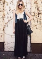 Longue demi-jupe noire en combinaison avec un gilet en jean