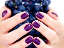 Manicure roxo sob o vestido esmeralda