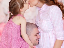 Séance photo d'une femme enceinte avec son mari et son enfant dans un studio photo