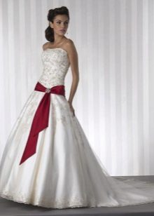 Robe de mariée avec un ruban rouge sur les hanches