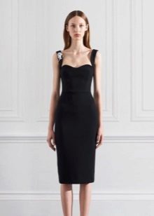 La robe de soirée au genou est noire avec des bretelles