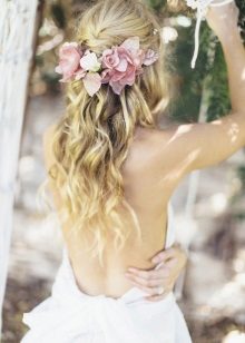 Coiffure avec des fleurs fraîches à la robe de mariée
