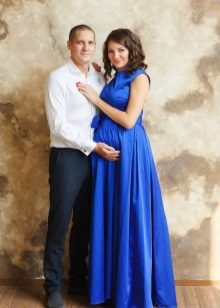 Séance photo pour une femme enceinte vêtue d'une robe longue bleue