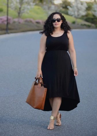 Robe noire avec une jupe asymétrique à combiner avec des sandales dorées et un sac marron