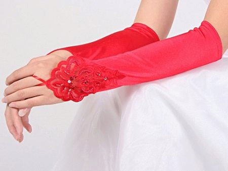 Gants rouges ton sur le ruban rouge de la robe de mariée