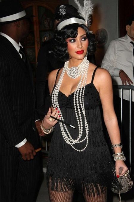 Robe noire dans le style de Gatsby en combinaison avec des perles et un petit sac à main